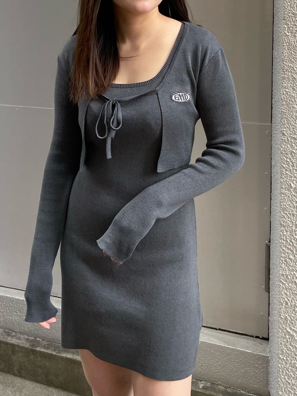 グレー系のワンピース、ブラック系のブーツを着用したレディースの春コーディネートの3枚目の写真