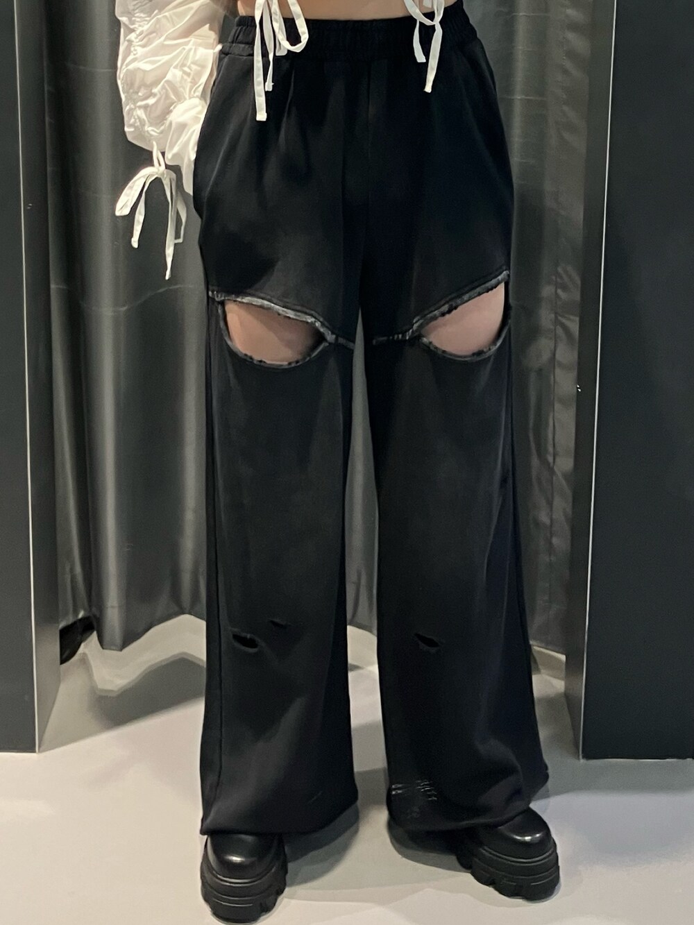 ブラック系のスウェットパンツ、ホワイト系のシャツ/ブラウス、ブラウン系のブーツを着用したレディースの秋コーディネートの5枚目の写真