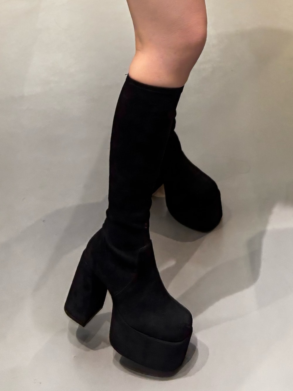 ブラック系のブーツ、ブラウン系のスカート、ブラウン系のダウンジャケット/コートを着用したレディースの冬コーディネートの5枚目の写真