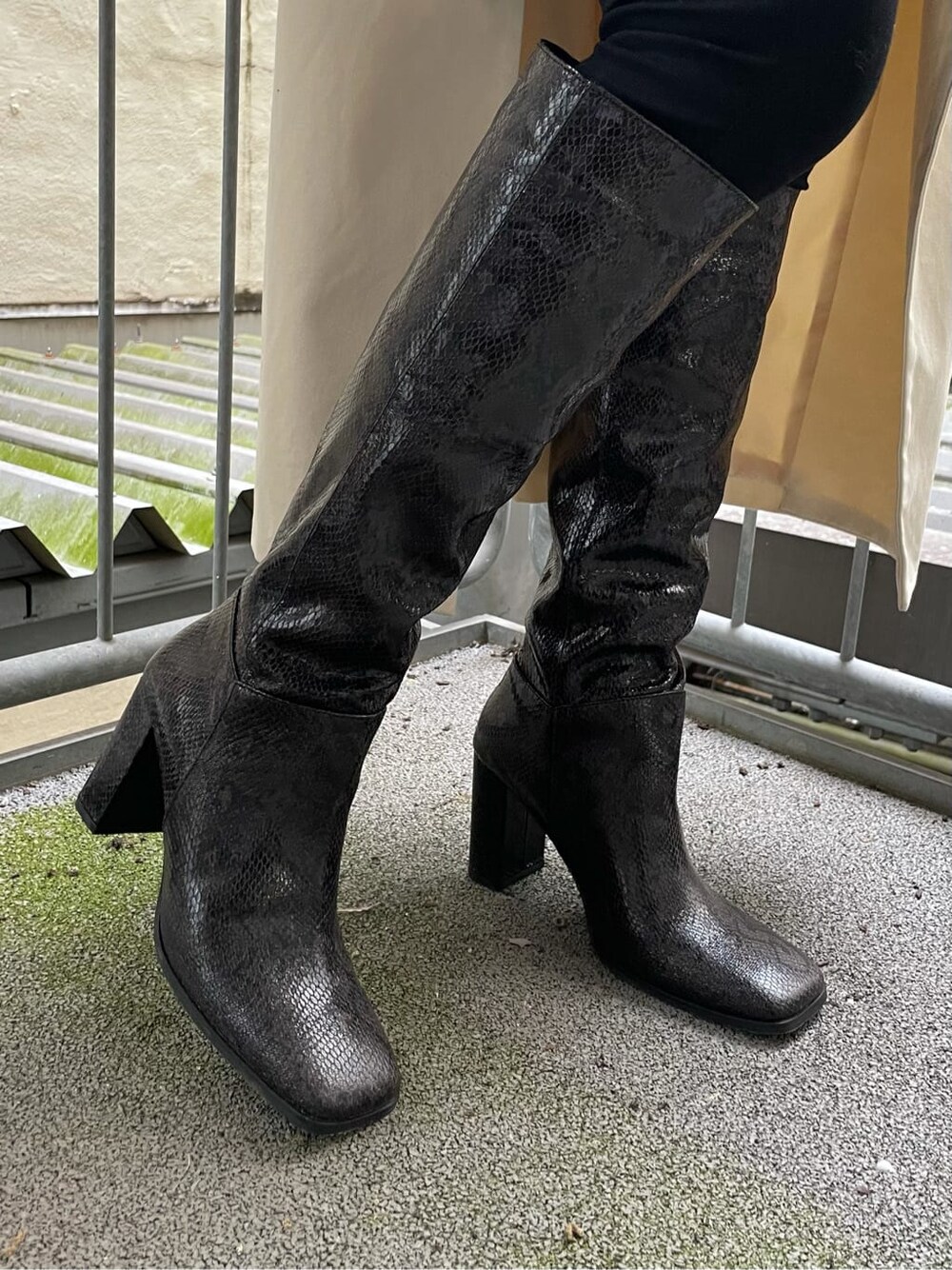 ブラック系のデニムパンツ、ホワイト系のトレンチコート、その他のブーツを着用したレディースの秋コーディネートの7枚目の写真