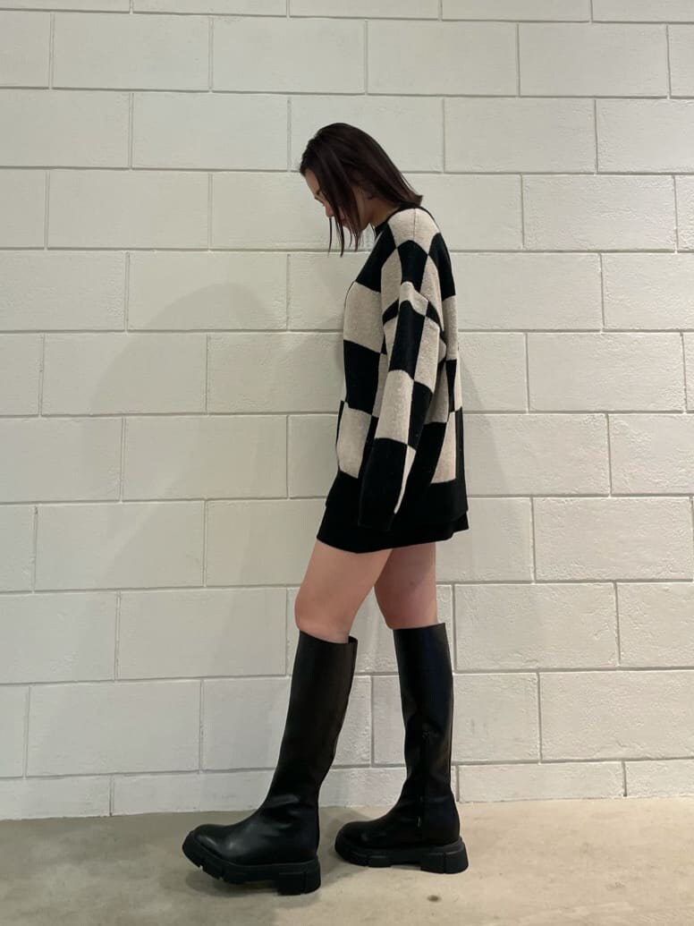 ブラック系のブーツ、ブラック系のスカート、ブラック系のニット/セーターを着用したレディースの冬コーディネートの3枚目の写真