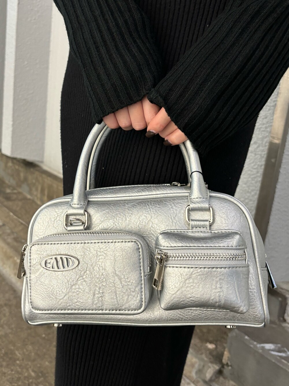 ブラック系のワンピース、ブラック系のブーツ、シルバー系のハンドバッグを着用したレディースの秋コーディネートの8枚目の写真