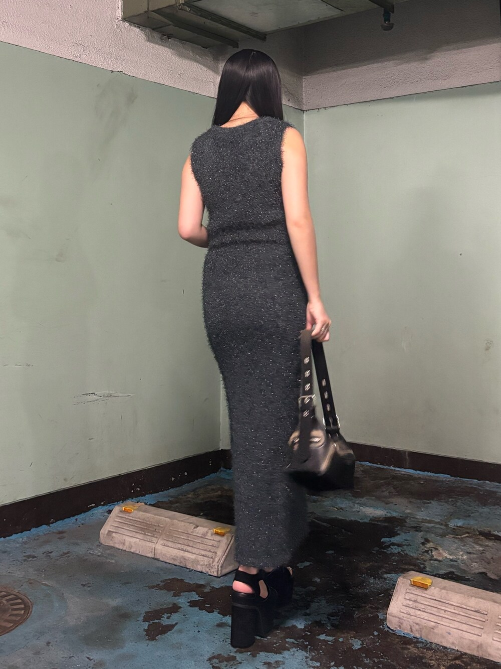 ブラック系のサンダル、ブラック系のハンドバッグ、グレー系のタンクトップを着用したレディースの夏コーディネートの3枚目の写真