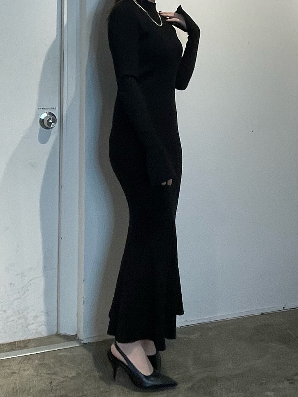 ブラック系のワンピース、ブラック系のパンプスを着用したレディースの冬コーディネートの3枚目の写真