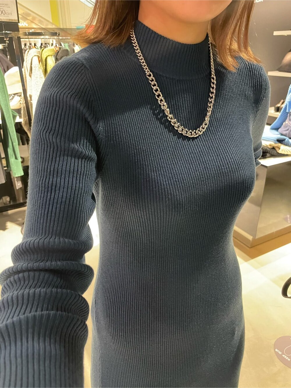 ブルー系のワンピース、ホワイト系のブーツ、シルバー系のネックレスを着用したレディースの冬コーディネートの3枚目の写真