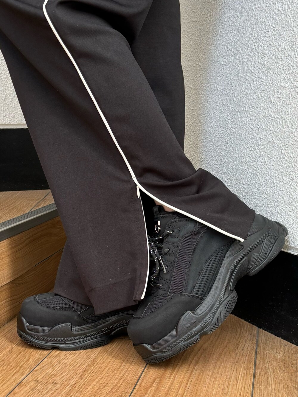 ブラック系のスラックス、ブラック系のニット/セーター、ブラック系のスニーカーを着用したレディースの冬コーディネートの7枚目の写真