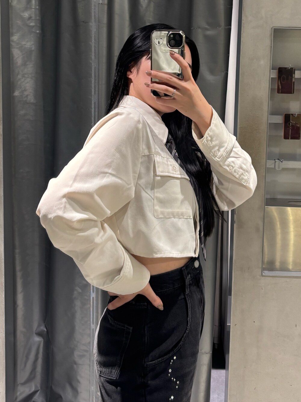 ブラック系のデニムパンツ、ブラック系のブーツ、ホワイト系のシャツ/ブラウスを着用したレディースの秋コーディネートの4枚目の写真