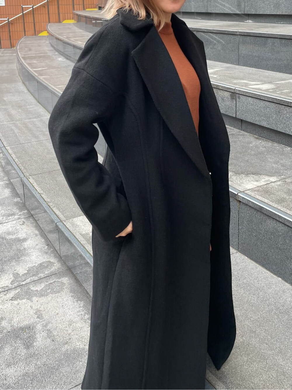 オレンジ系のニット/セーター、その他のブーツ、ブラック系のその他アウターを着用したレディースの秋コーディネートの3枚目の写真