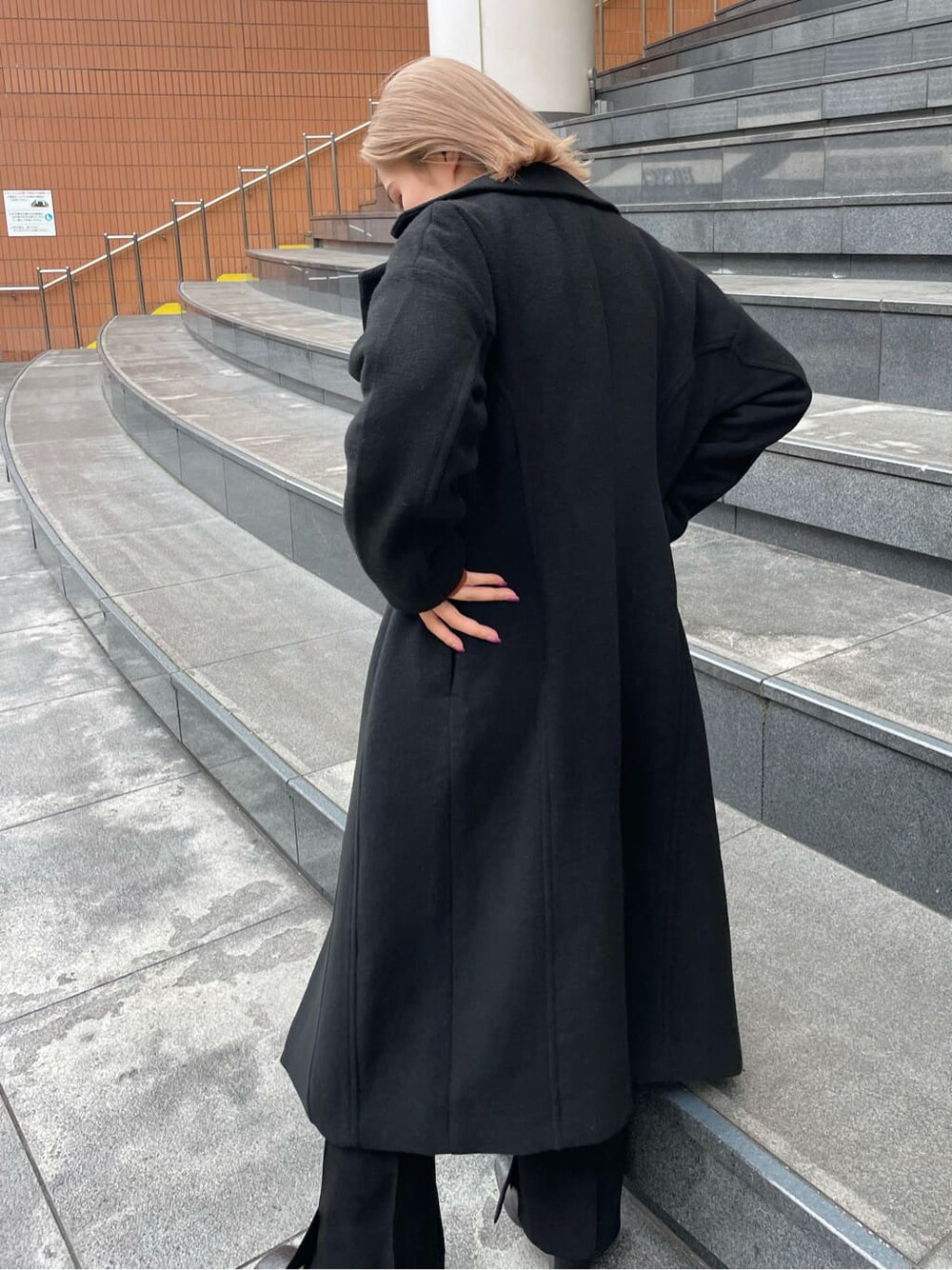 オレンジ系のニット/セーター、その他のブーツ、ブラック系のその他アウターを着用したレディースの秋コーディネートの4枚目の写真