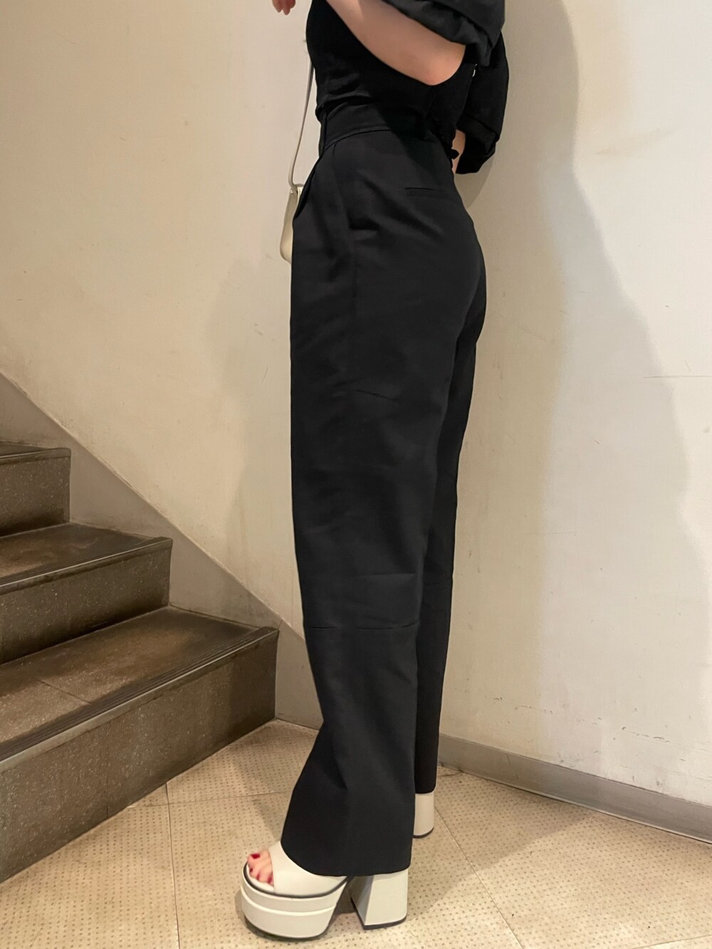 ブラック系のシャツ/ブラウス、ブラック系のその他パンツ、ホワイト系のサンダルを着用したレディースの春コーディネートの8枚目の写真