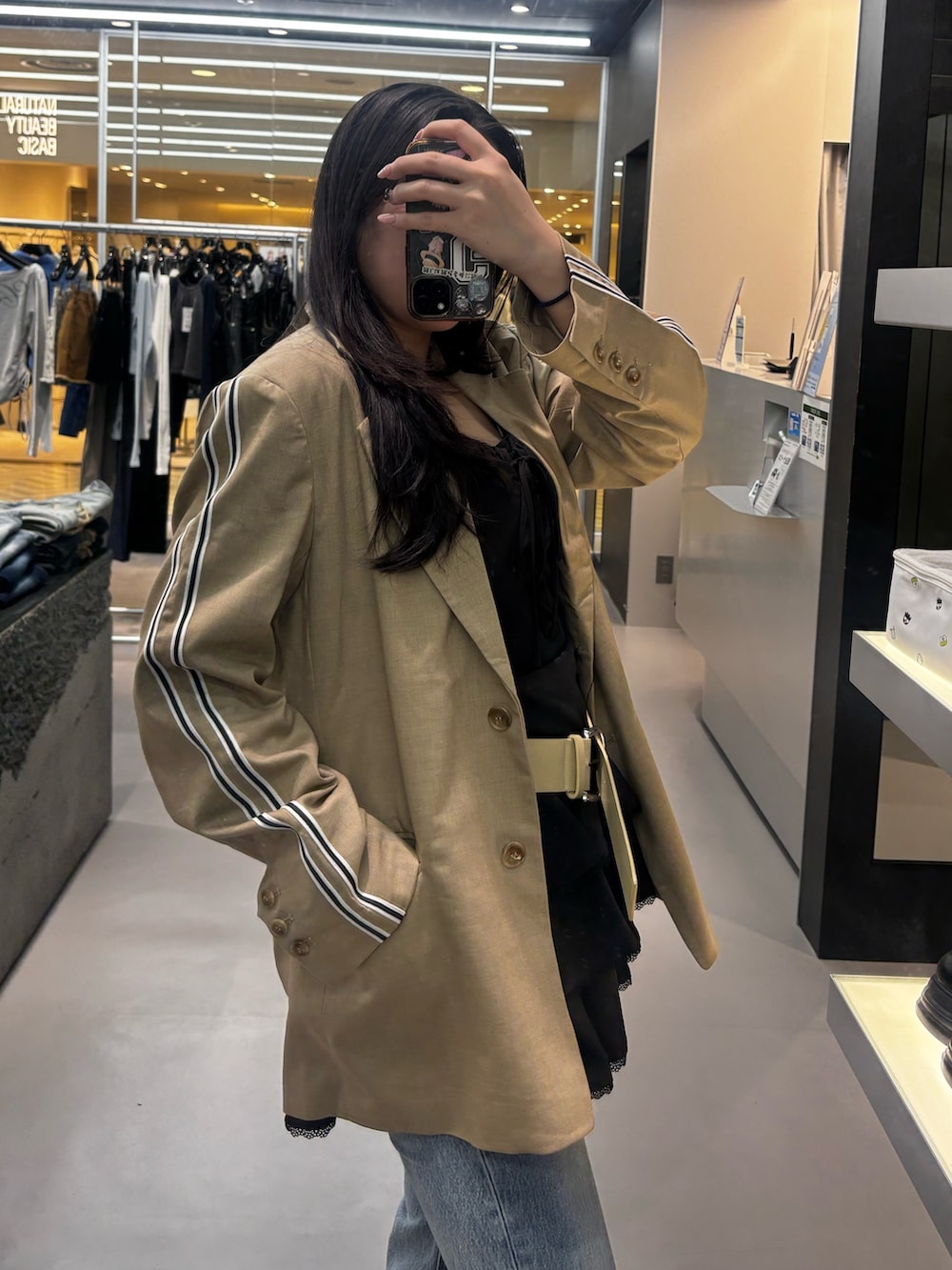 ブラック系のワンピース、グレー系のテーラードジャケット、ブラック系のスニーカーを着用したレディースの春コーディネートの4枚目の写真