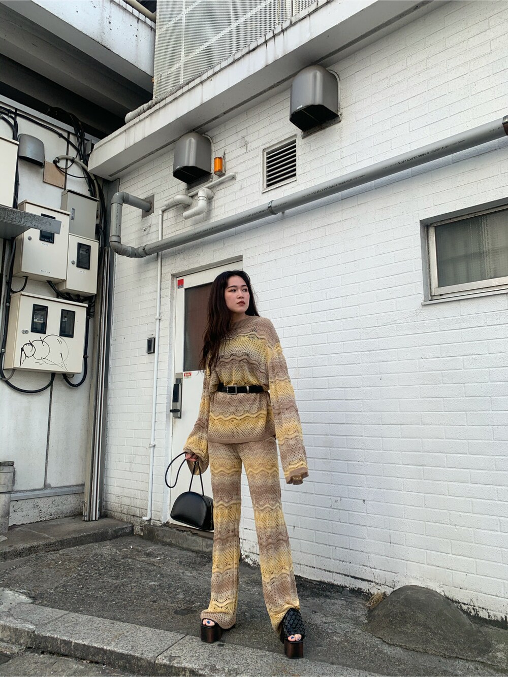 ベージュ系のその他パンツ、ブラック系のサンダル、ベージュ系のニット/セーターを着用したレディースの春コーディネートの4枚目の写真