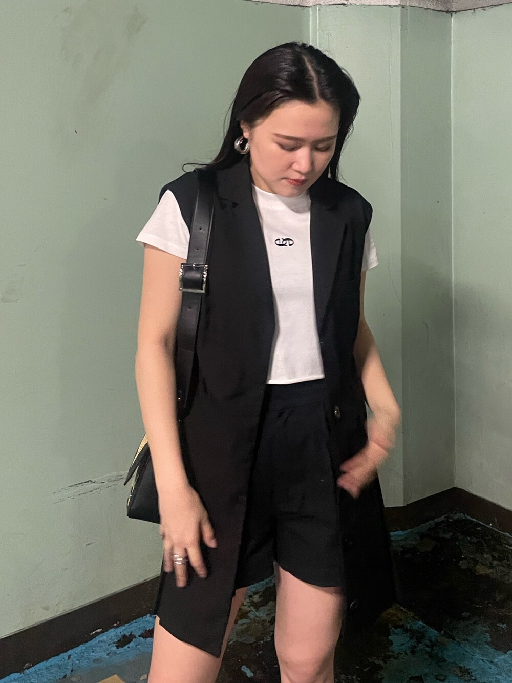 ベージュ系のショルダーバッグ、ブラック系のサンダル、ブラック系のワンピースを着用したレディースの夏コーディネートの4枚目の写真