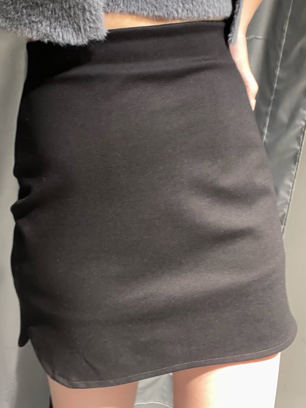 グレー系のニット/セーター、ブラック系のスカート、ブラック系のブーツを着用したレディースの夏コーディネートの4枚目の写真