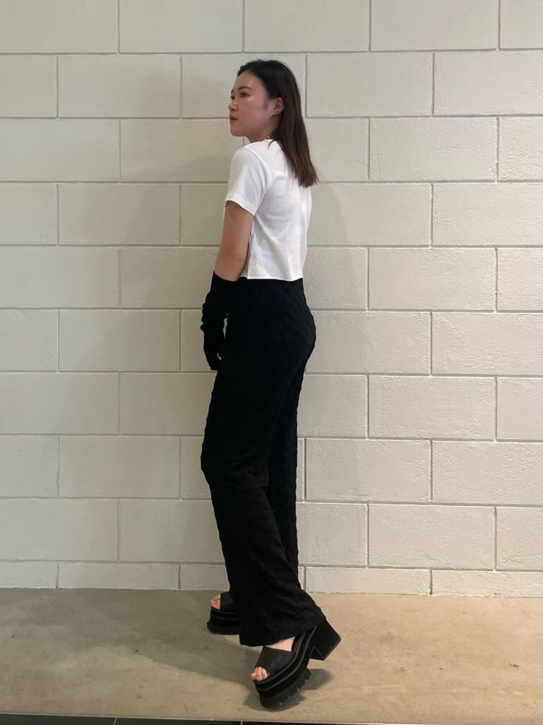 ブラック系のその他パンツ、ブラック系のサンダル、ホワイト系のTシャツ/カットソーを着用したレディースの夏コーディネートの2枚目の写真
