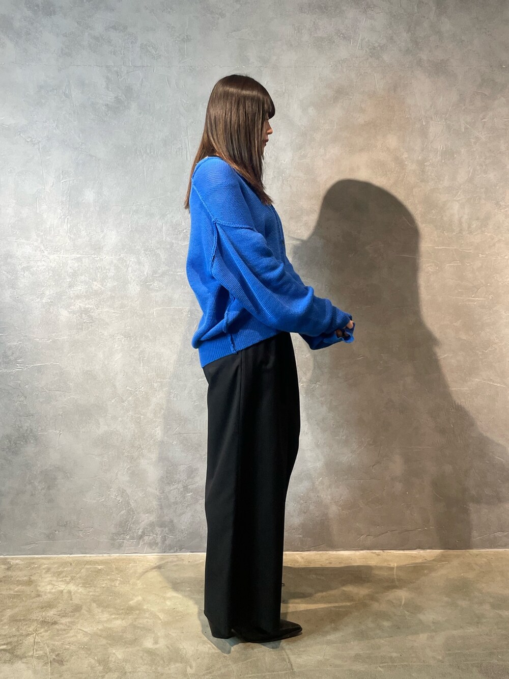 ブラック系のその他パンツ、ブラック系のブーツ、ブルー系のカーディガン/ボレロを着用したレディースの冬コーディネートの2枚目の写真