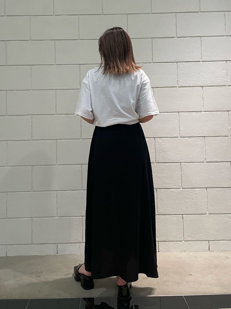 ブラック系のサンダル、ブラック系のワンピース、ホワイト系のTシャツ/カットソーを着用したレディースの春コーディネートの2枚目の写真