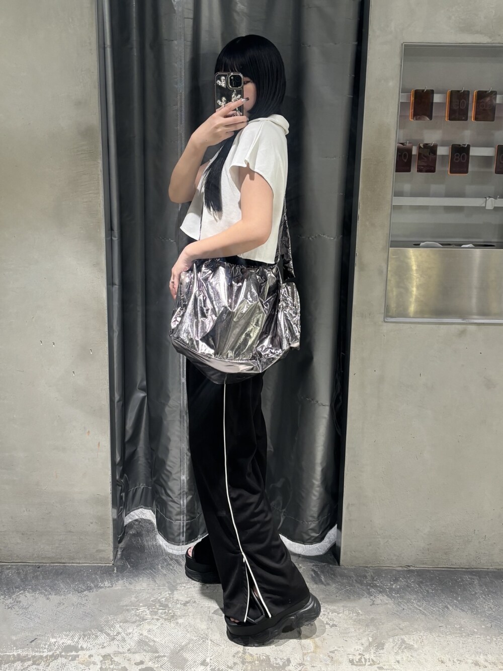 ブラック系のサンダル、ホワイト系のTシャツ/カットソー、ブラック系のスラックスを着用したレディースの夏コーディネートの2枚目の写真