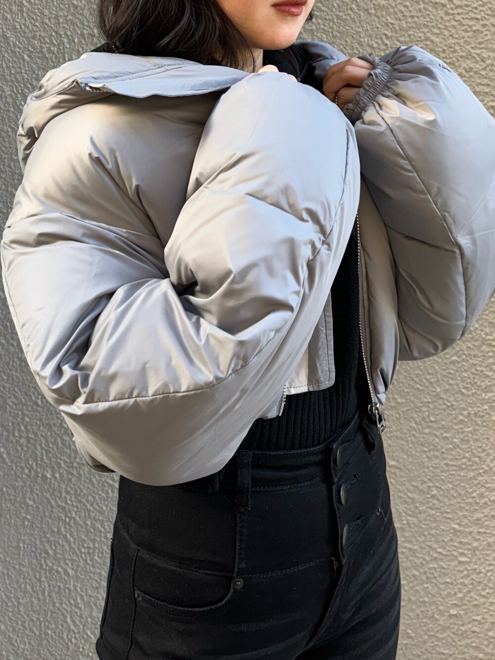 ブルー系のニット/セーター、グレー系のダウンジャケット/コート、ブラック系のデニムパンツを着用したレディースの冬コーディネートの4枚目の写真