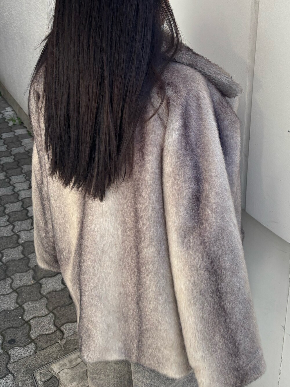 グレー系のその他アウター、ブラック系のニット/セーター、ブラック系のハンドバッグを着用したレディースの冬コーディネートの5枚目の写真