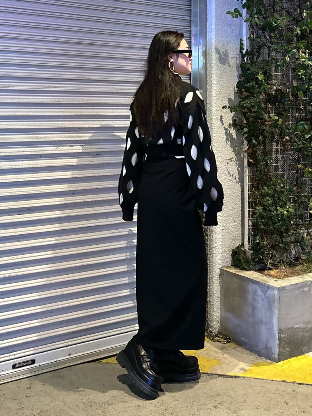 ブラック系のローファー、ブラック系のスカート、ブラック系のニット/セーターを着用したレディースの冬コーディネートの2枚目の写真