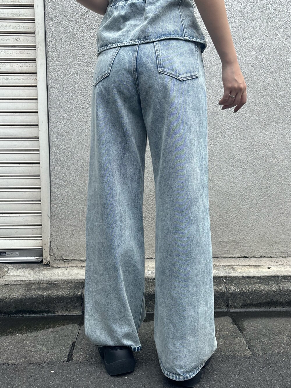 ブラック系のサンダル、ブルー系のデニムパンツ、ブルー系のキャミソールを着用したレディースの夏コーディネートの7枚目の写真