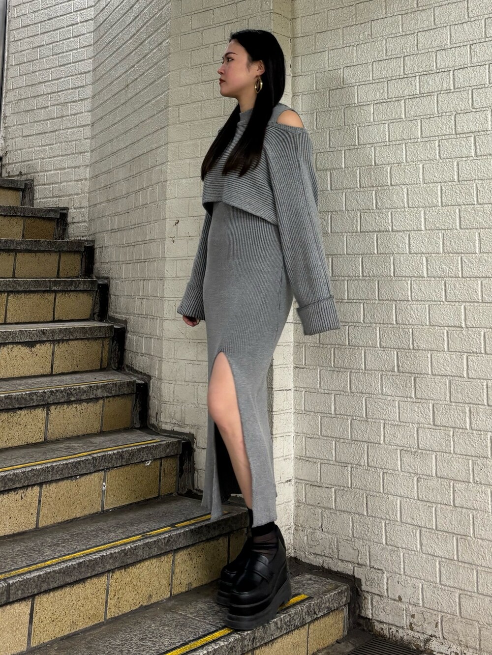 グレー系のワンピース、ブラック系のローファーを着用したレディースの冬コーディネートの2枚目の写真