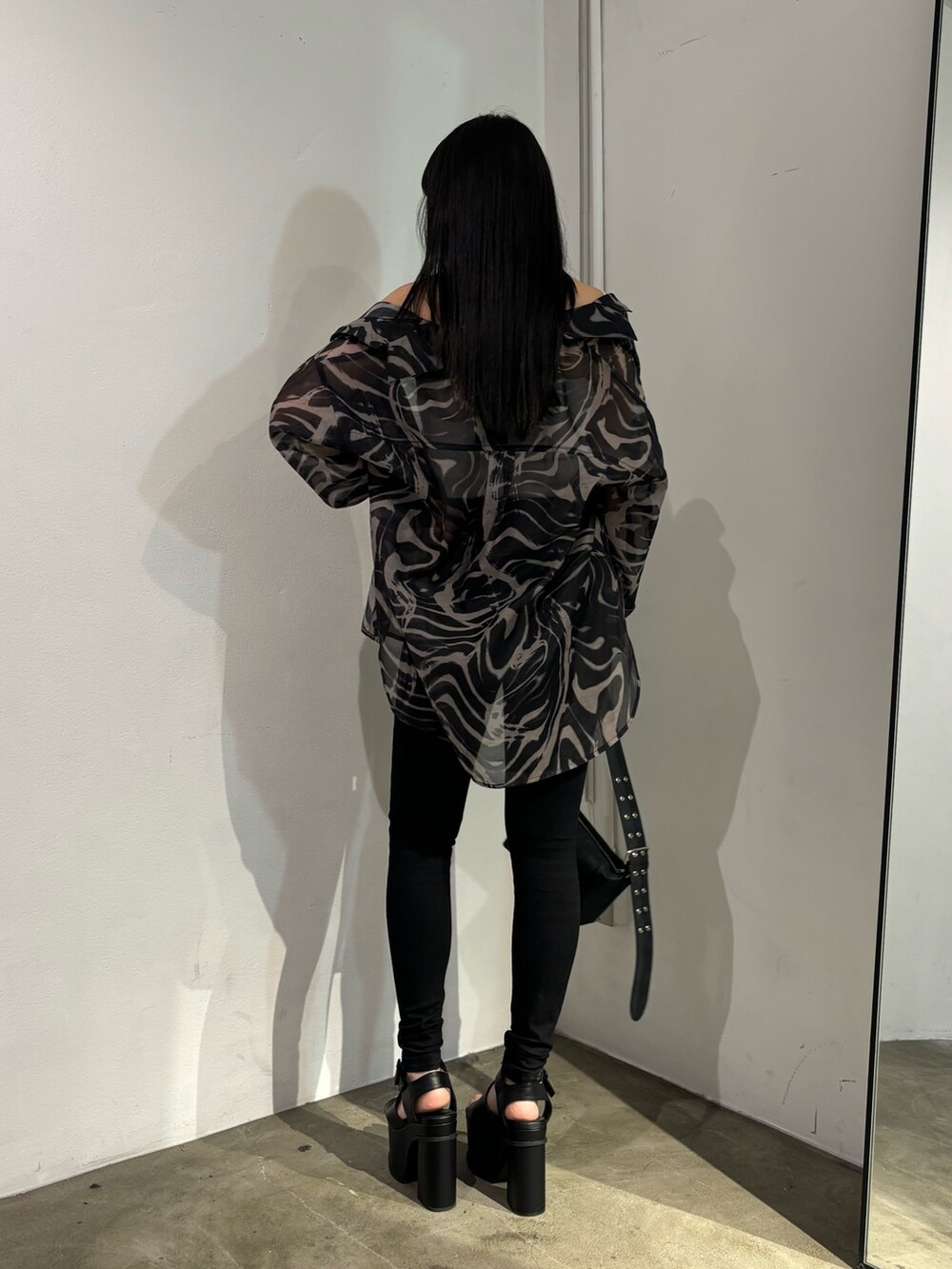 ブラック系のデニムパンツ、ベージュ系のシャツ/ブラウス、ブラック系のショルダーバッグを着用したレディースの春コーディネートの3枚目の写真