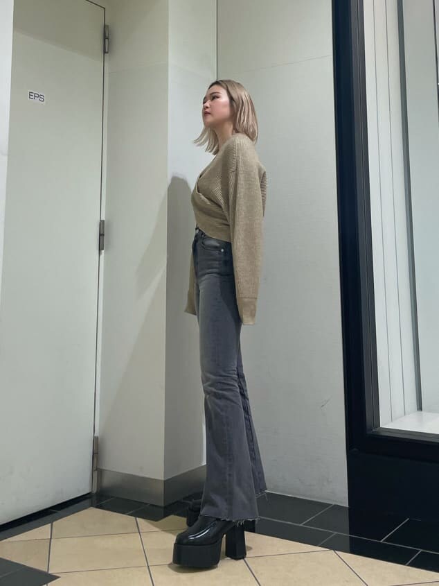 ブラック系のローファー、グレー系のデニムパンツ、ベージュ系のニット/セーターを着用したレディースの冬コーディネートの2枚目の写真