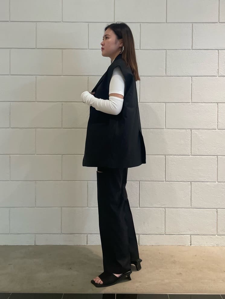 ブラック系のベスト、ブラック系のその他パンツ、ブラック系のサンダルを着用したレディースの夏コーディネートの2枚目の写真