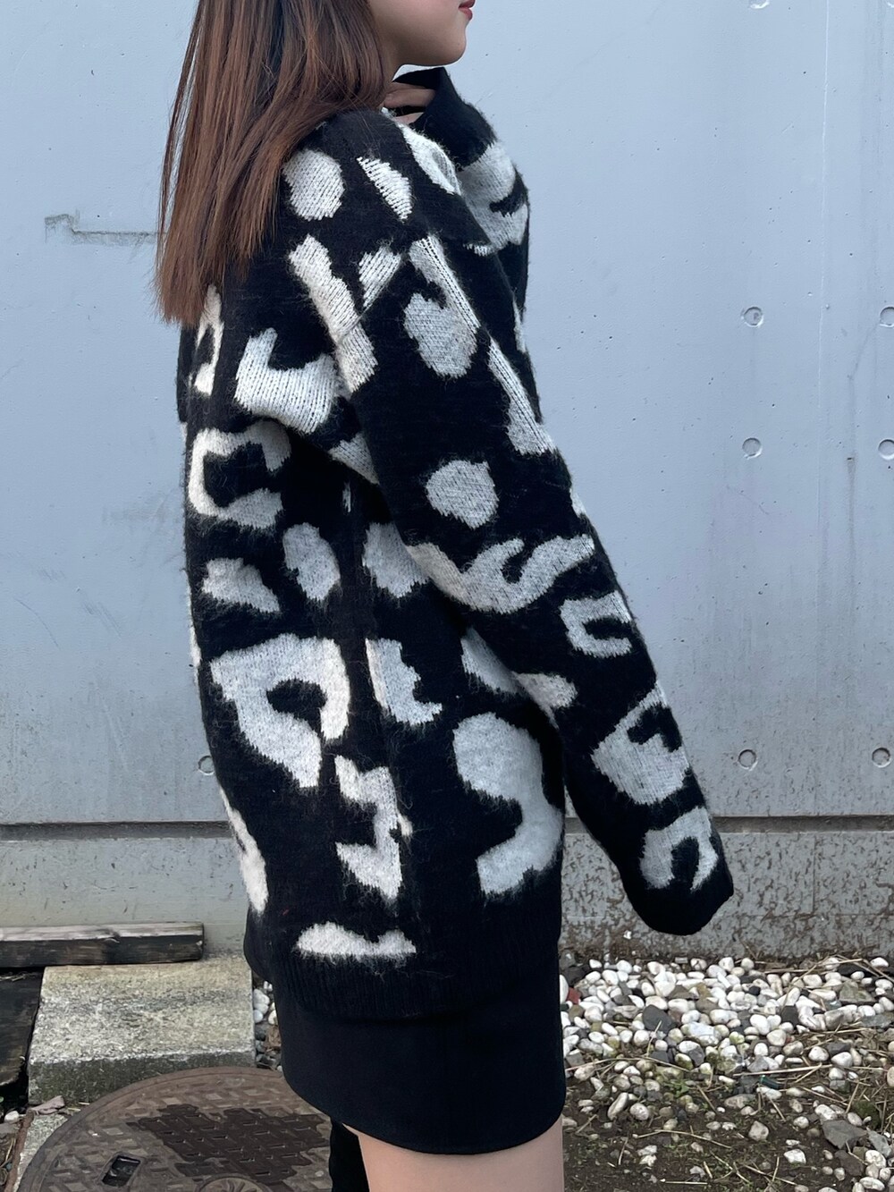 ブラック系のニット/セーター、ブラック系のスカート、ブラック系のブーツを着用したレディースの冬コーディネートの4枚目の写真