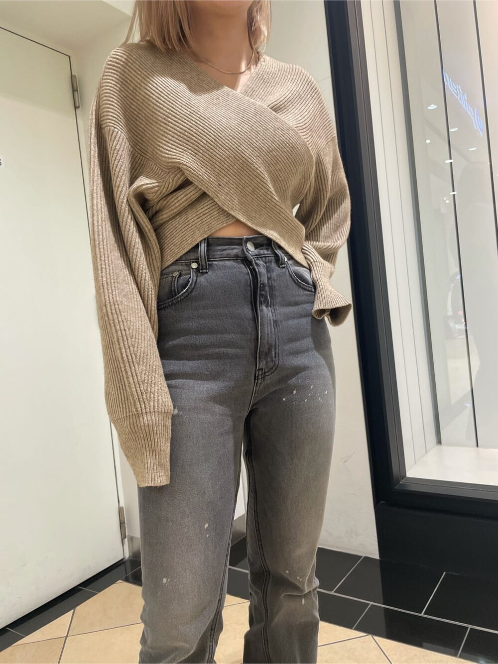 ブラック系のローファー、グレー系のデニムパンツ、ベージュ系のニット/セーターを着用したレディースの冬コーディネートの6枚目の写真