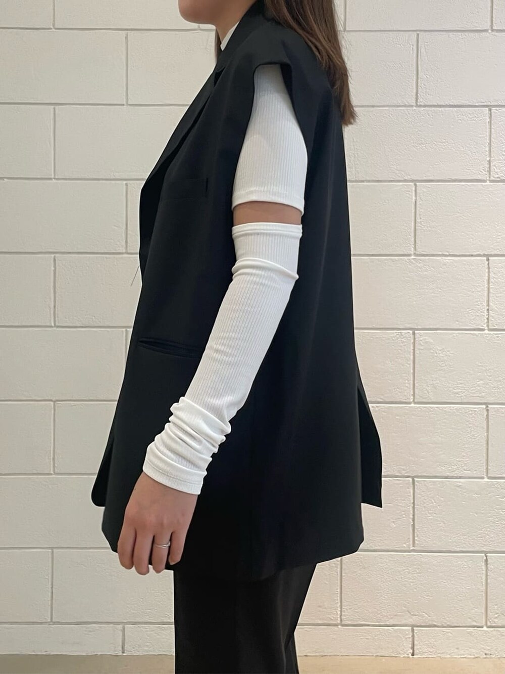 ブラック系のベスト、ブラック系のその他パンツ、ブラック系のサンダルを着用したレディースの夏コーディネートの4枚目の写真