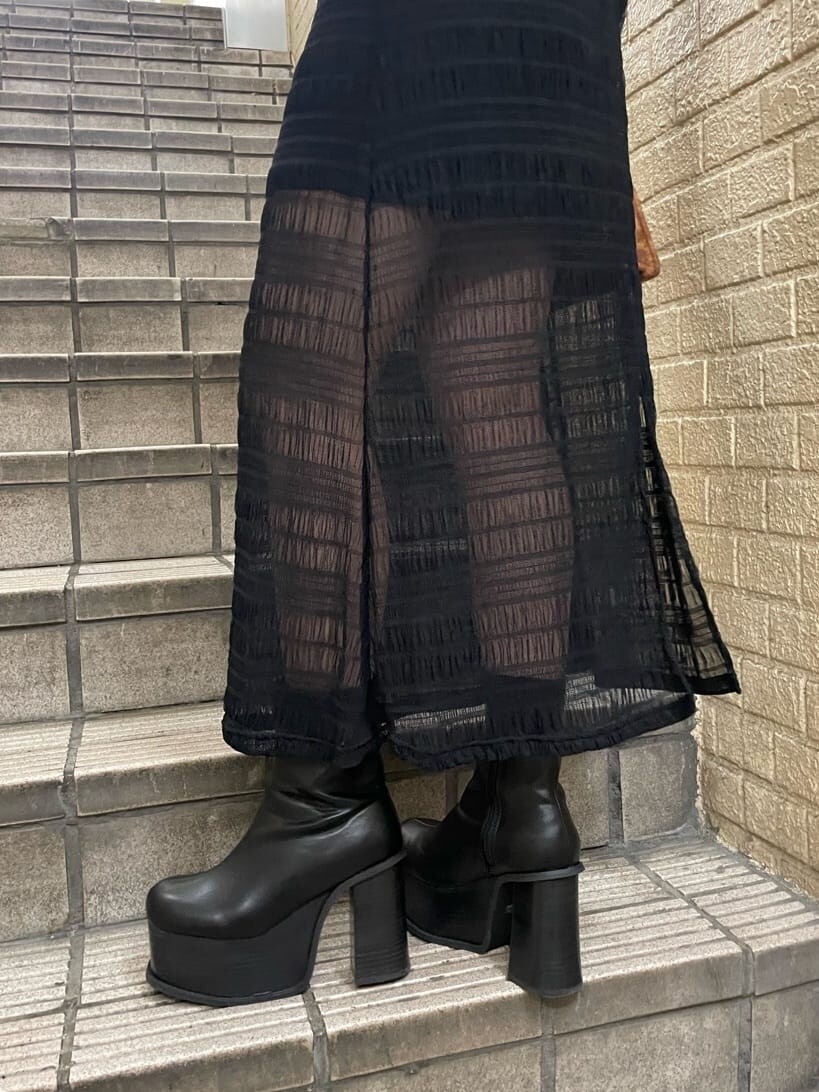 ブラック系のブーツ、ブラック系のワンピース、シルバー系のネックレスを着用したレディースの秋コーディネートの5枚目の写真