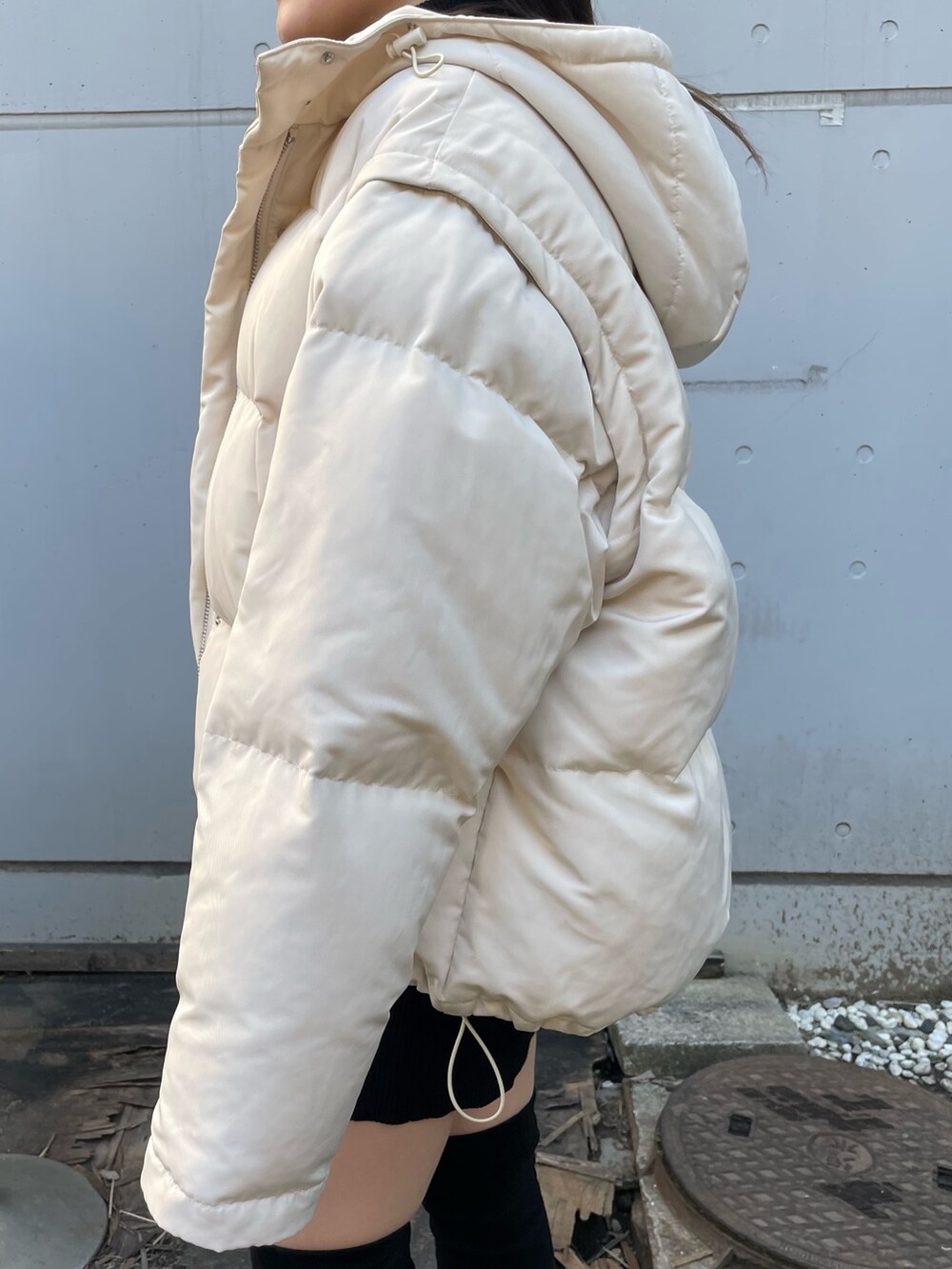 ホワイト系のダウンジャケット/コート、ブラック系のワンピース、ブラック系のブーツを着用したレディースの冬コーディネートの7枚目の写真