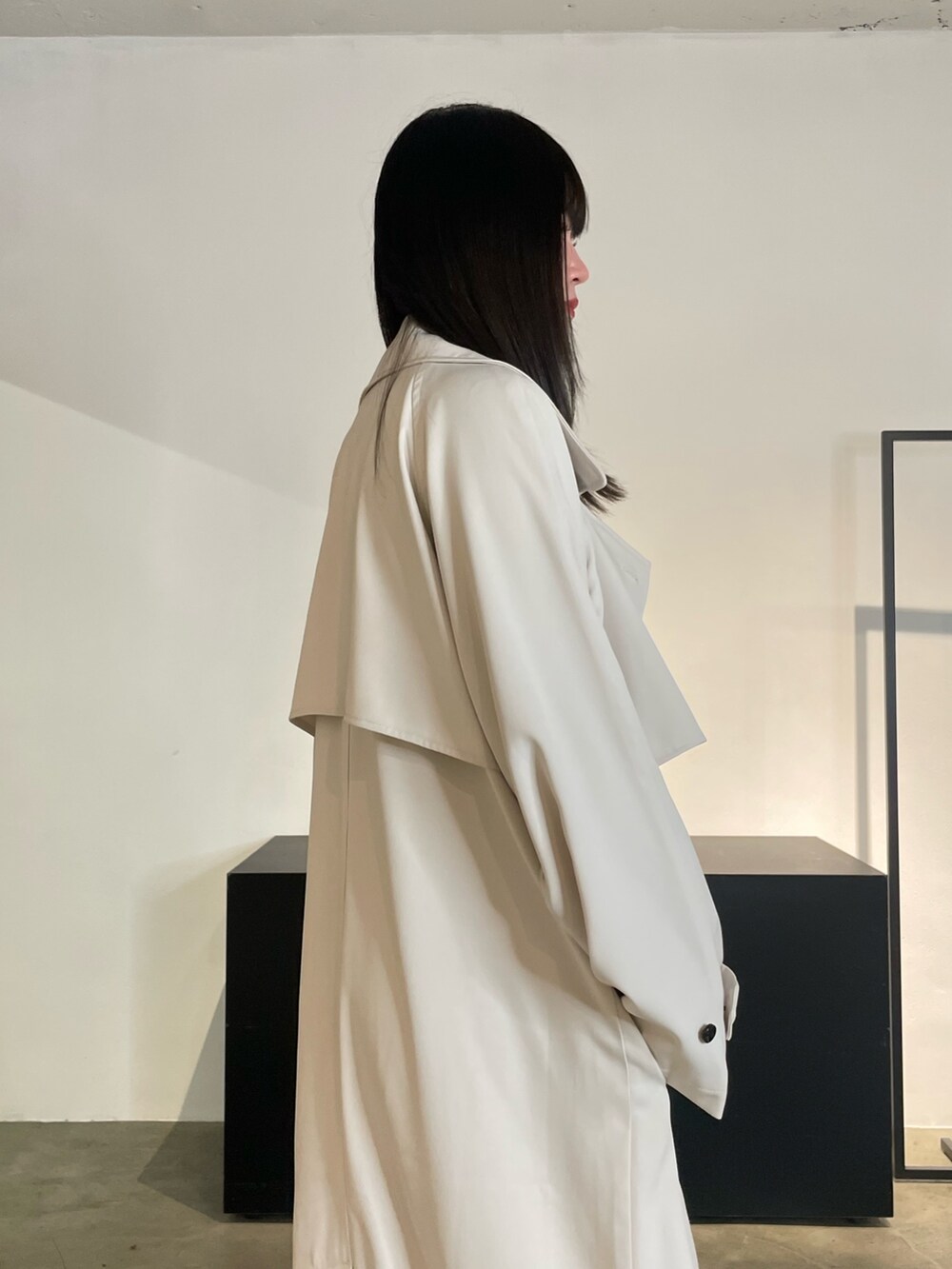 グリーン系のトレンチコート、ブラック系のパンプス、ブルー系のデニムパンツを着用したレディースの冬コーディネートの6枚目の写真