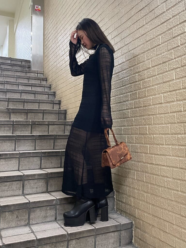 ブラック系のブーツ、ブラック系のワンピース、シルバー系のネックレスを着用したレディースの秋コーディネートの2枚目の写真