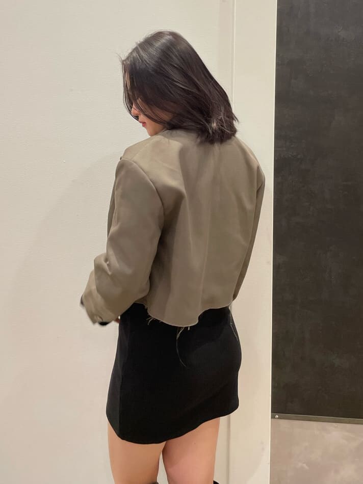 ブラック系のワンピース、ブラウン系のテーラードジャケット、ブラック系のブーツを着用したレディースの春コーディネートの4枚目の写真