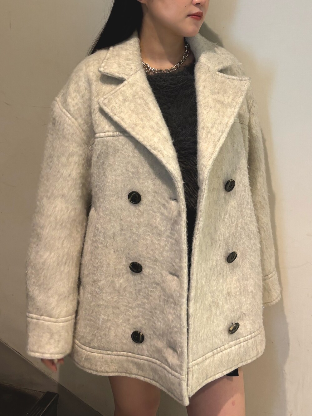 その他のブーツ、ホワイト系のピーコート、グレー系のニット/セーターを着用したレディースの秋コーディネートの4枚目の写真