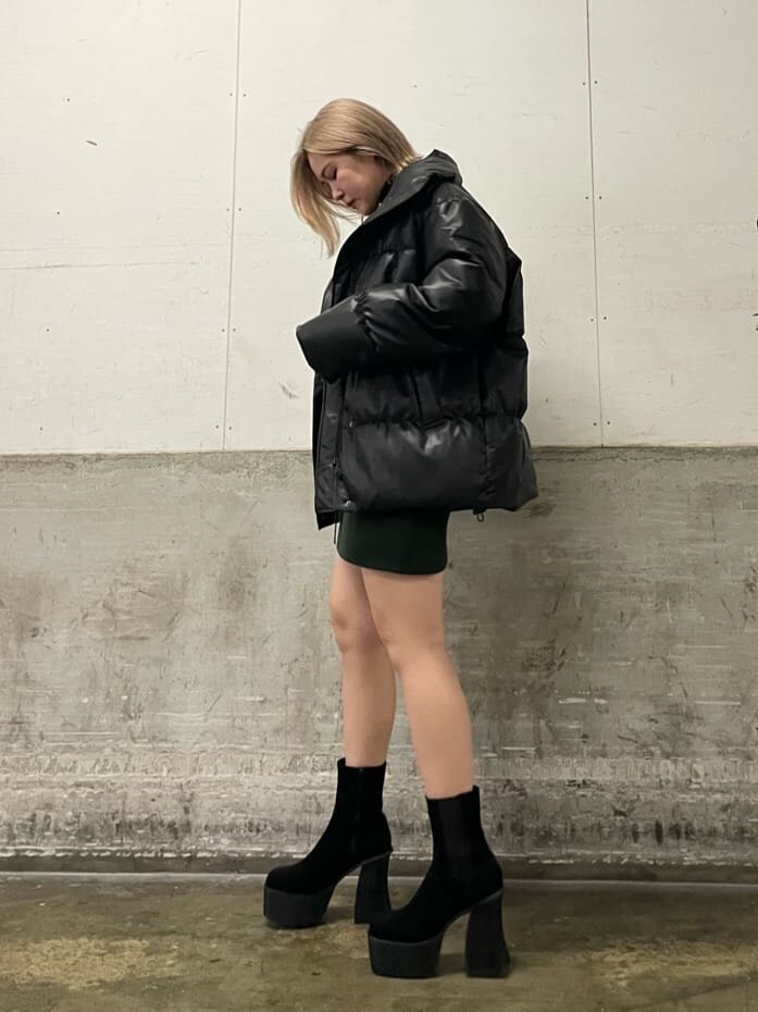 ブラック系のブーツ、その他のダウンジャケット/コート、グリーン系のワンピースを着用したレディースの秋コーディネートの2枚目の写真