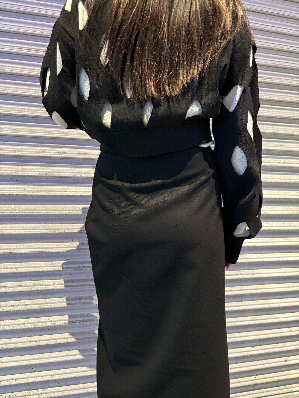 ブラック系のローファー、ブラック系のスカート、ブラック系のニット/セーターを着用したレディースの冬コーディネートの6枚目の写真