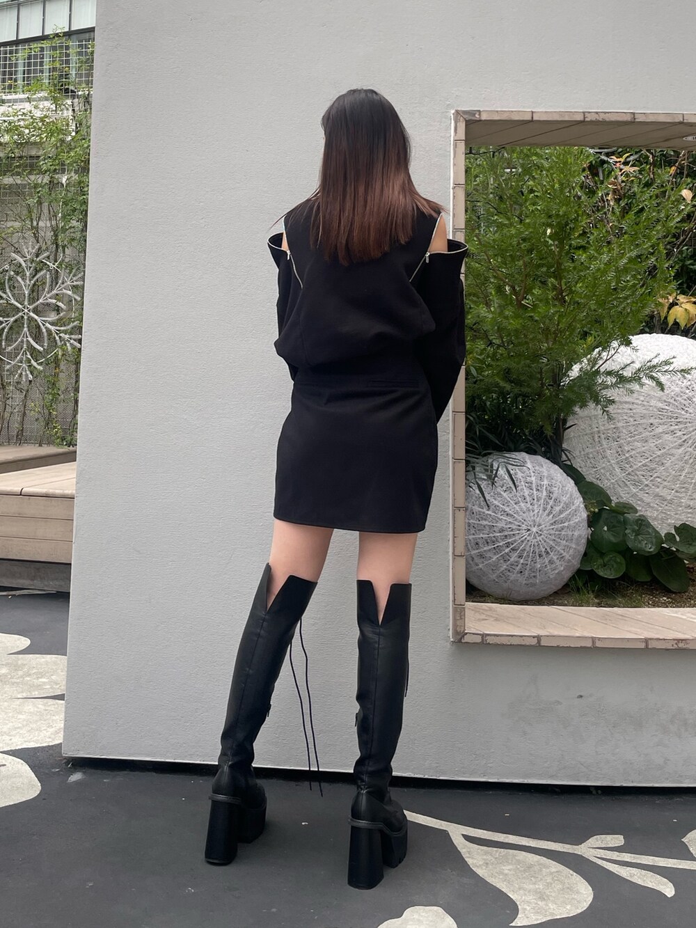 ブラック系のTシャツ/カットソー、ブラック系のスカート、ブラック系のブーツを着用したレディースの冬コーディネートの3枚目の写真