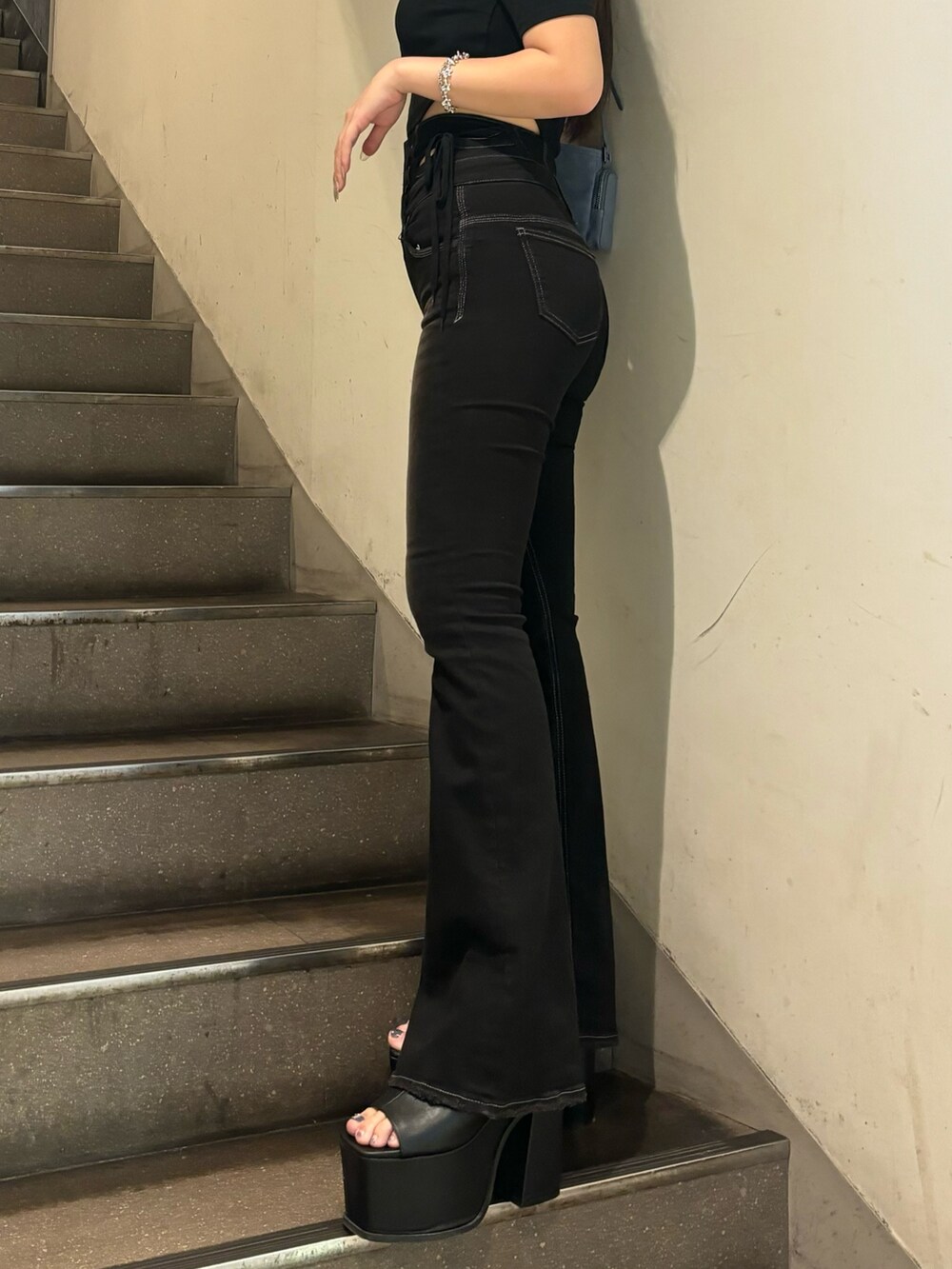 ブラック系のデニムパンツ、ホワイト系のサンダル、ブラック系のTシャツ/カットソーを着用したレディースの夏コーディネートの5枚目の写真