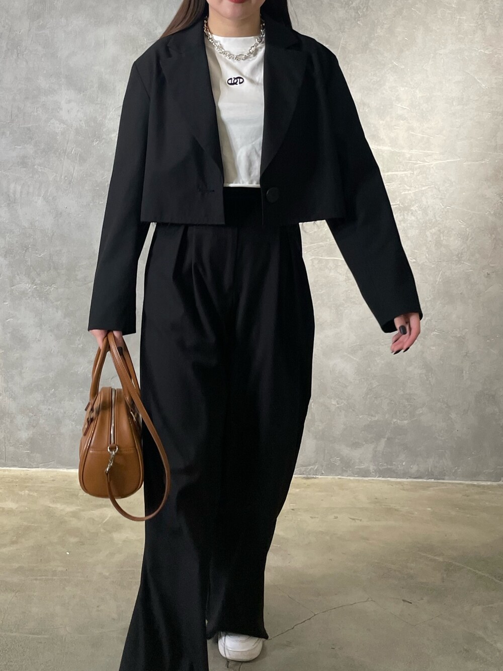 ブラック系のテーラードジャケット、ブラック系のその他パンツ、ホワイト系のTシャツ/カットソーを着用したレディースの冬コーディネートの4枚目の写真