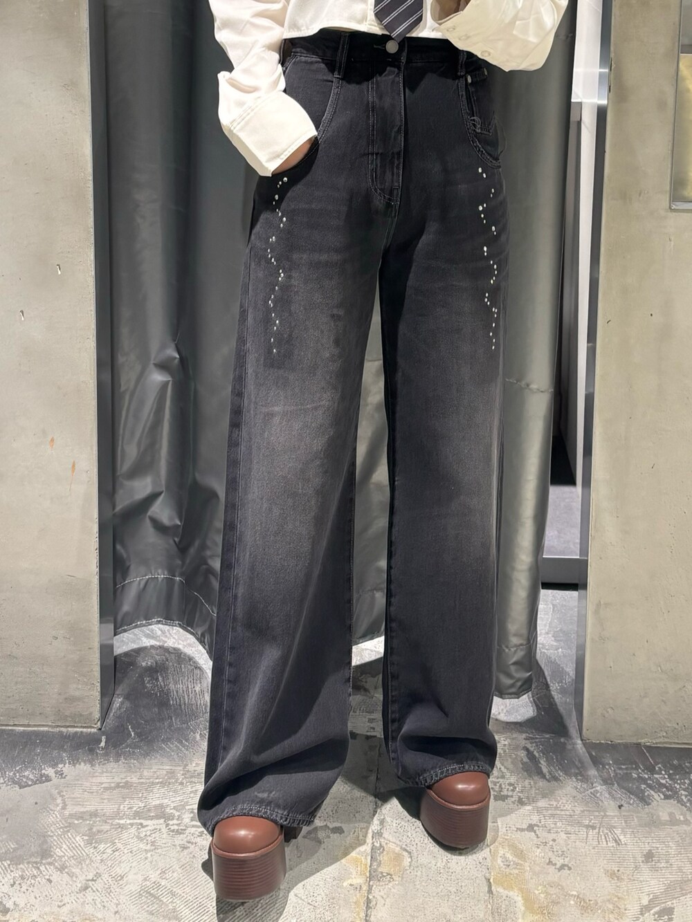 ブラック系のデニムパンツ、ブラック系のブーツ、ホワイト系のシャツ/ブラウスを着用したレディースの秋コーディネートの5枚目の写真