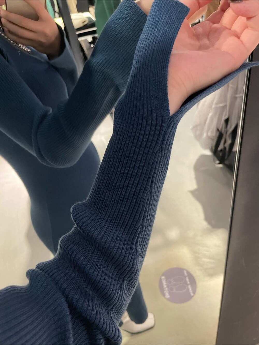 ブルー系のワンピース、ホワイト系のブーツ、シルバー系のネックレスを着用したレディースの冬コーディネートの4枚目の写真