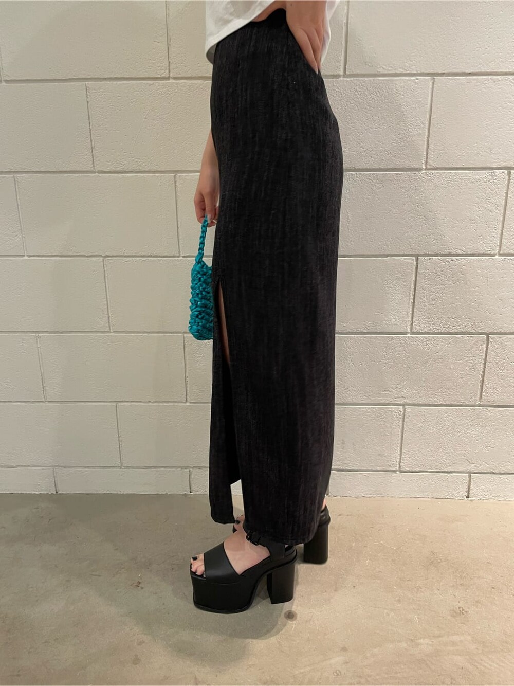 ブラック系のサンダル、ブラック系のスカート、ブルー系のハンドバッグを着用したレディースの春コーディネートの7枚目の写真