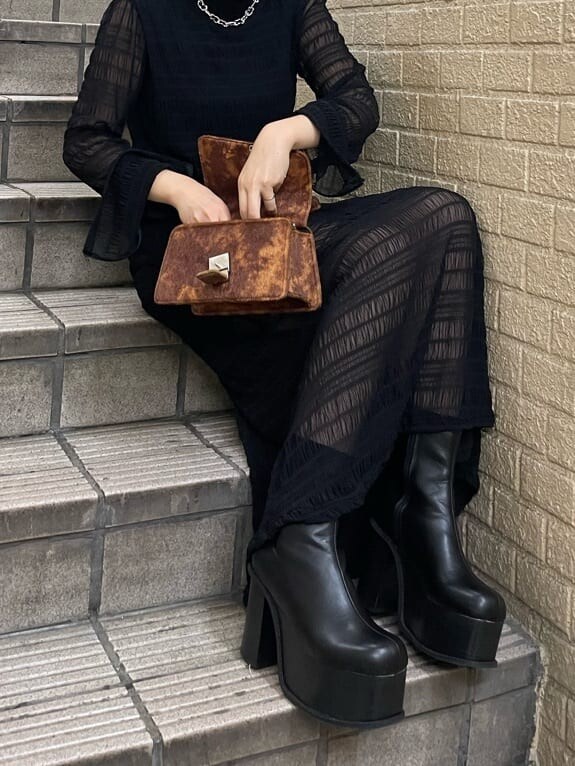 ブラック系のブーツ、ブラック系のワンピース、シルバー系のネックレスを着用したレディースの秋コーディネートの7枚目の写真