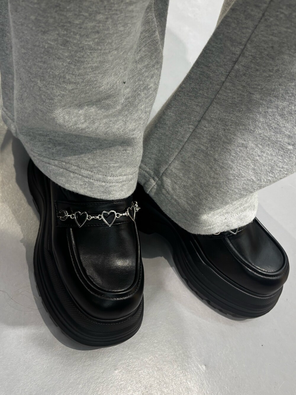 ブラック系のニット/セーター、グレー系のスウェットパンツ、ブラック系のローファーを着用したレディースの冬コーディネートの8枚目の写真