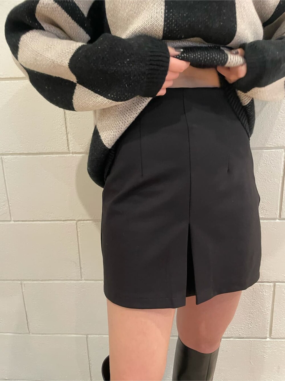 ブラック系のブーツ、ブラック系のスカート、ブラック系のニット/セーターを着用したレディースの冬コーディネートの7枚目の写真